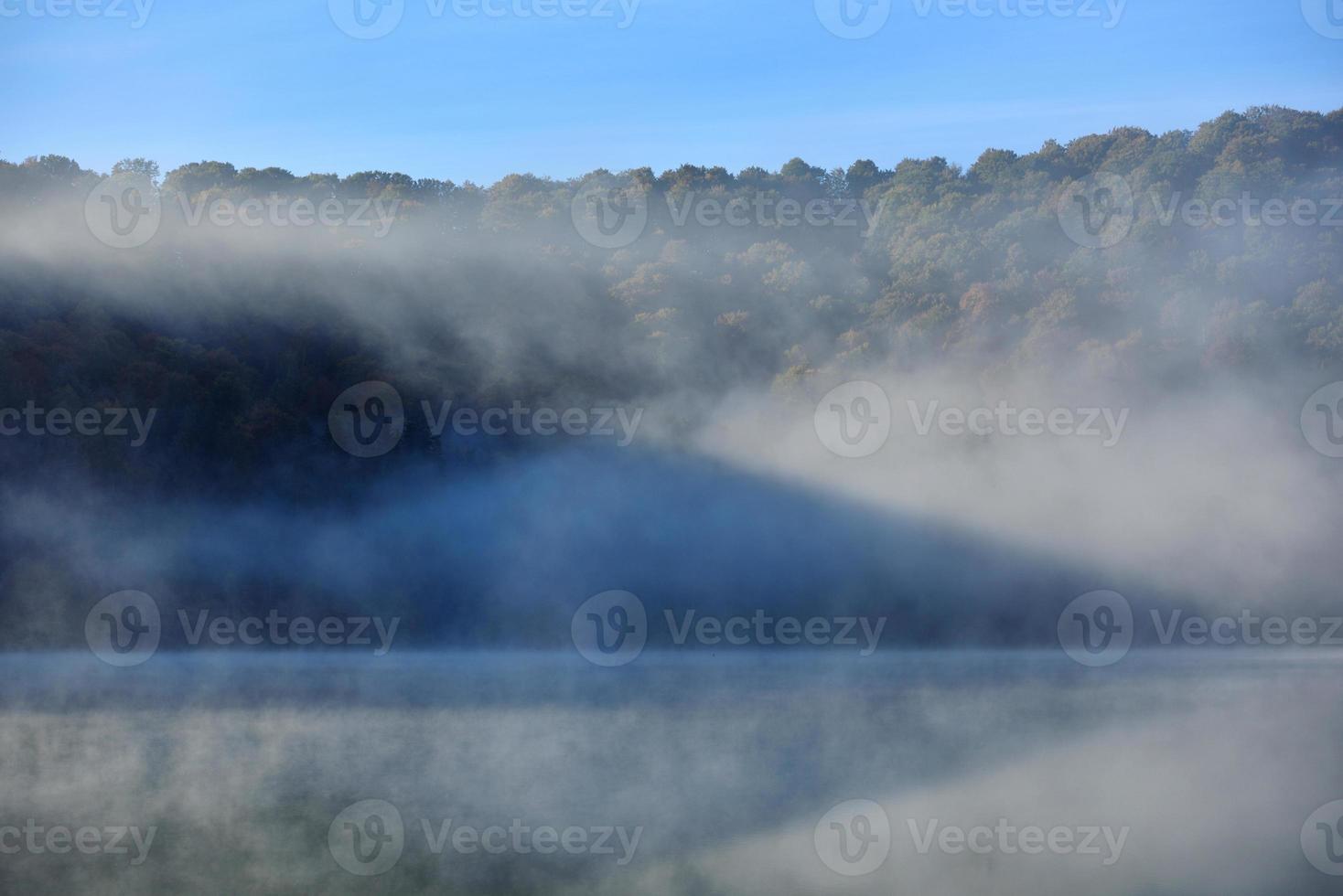 herfst landschap in de bergen met bomen weerspiegelen in het water bij st ana lake roemenië foto