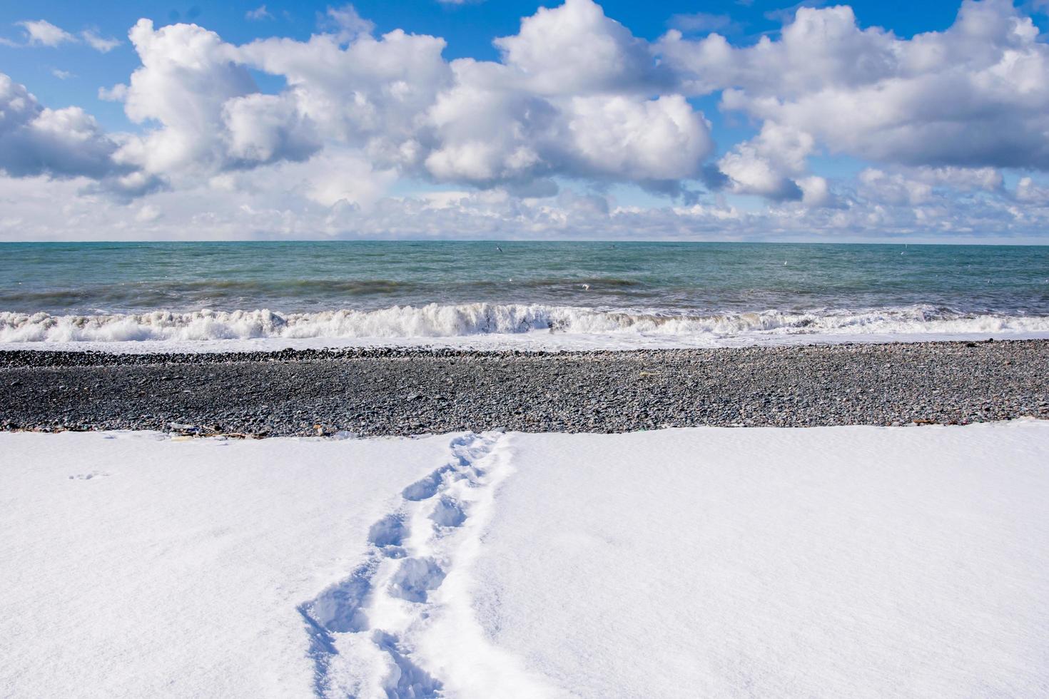 voetstappen op het strand met sneeuw foto