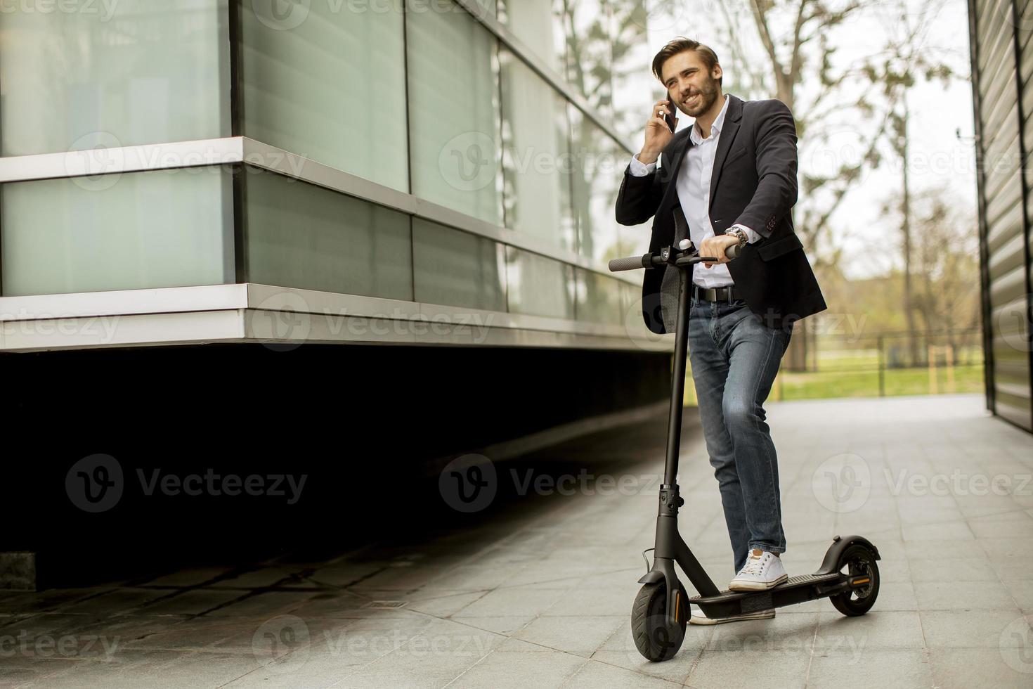 man praten aan een telefoon terwijl hij op een scooter zit foto