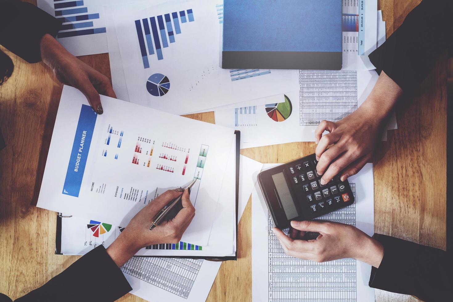economische onderzoeksdiscussies, business team analyseert inkomensgrafieken en grafieken om marketingconcept te plannen met behulp van pen en rekenmachine voor analyse. foto