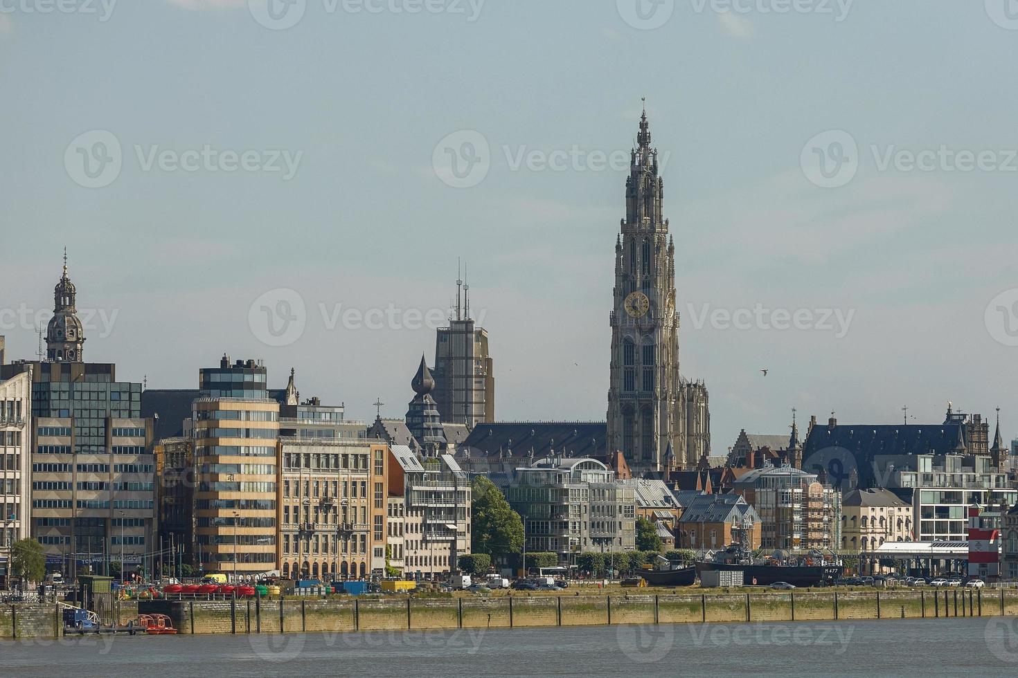 zicht op een haven van antwerpen en de kathedraal van onze lieve vrouw in belgië over de rivier foto