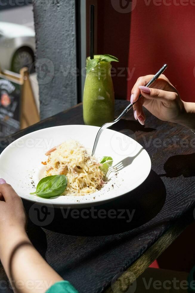 vrouw aan het eten Italiaans pasta zittend Bij de cafe teller op zoek naar de venster, hebben lunch foto