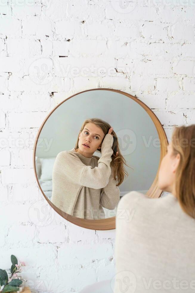 vrouw op zoek Bij de spiegel, maken omhoog in de ochtend- foto