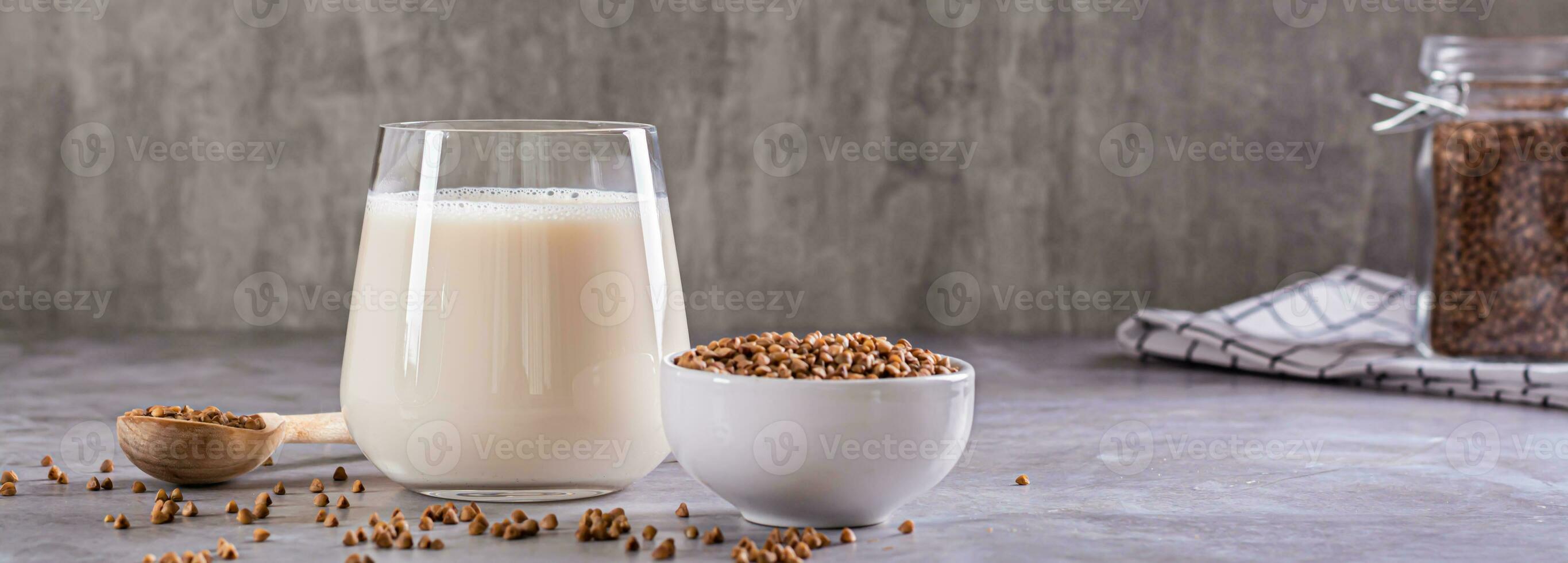 veganistisch zuivel vrij boekweit melk in een glas en granen in een kom Aan de tafel web banier foto