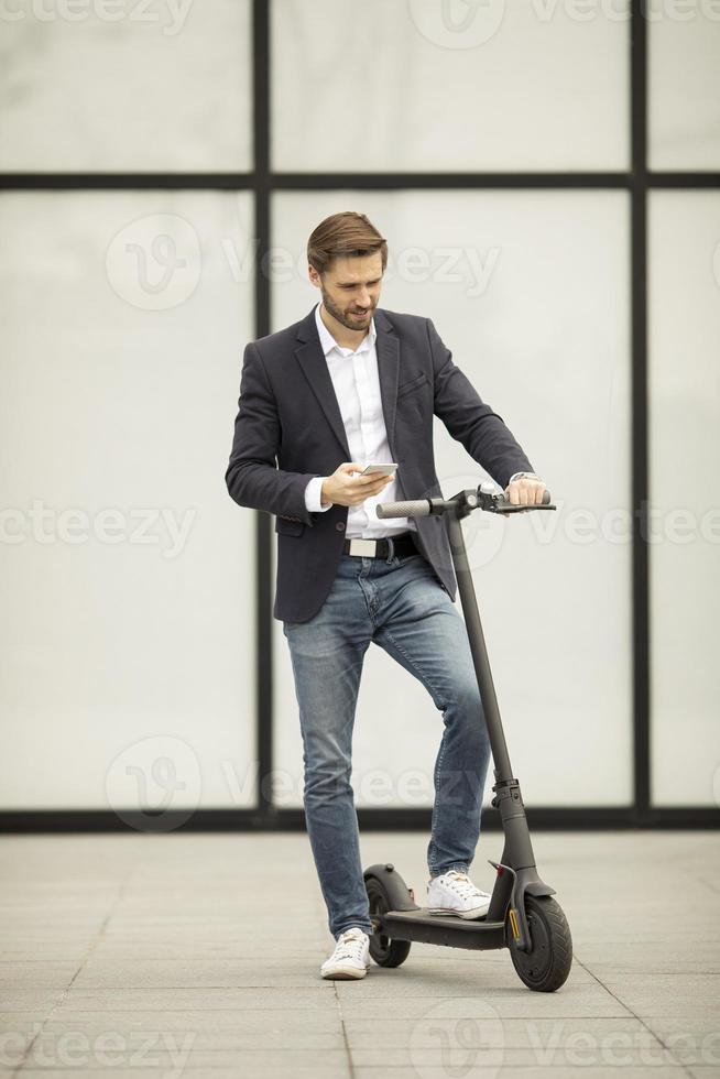 man kijkt naar telefoon op een scooter foto