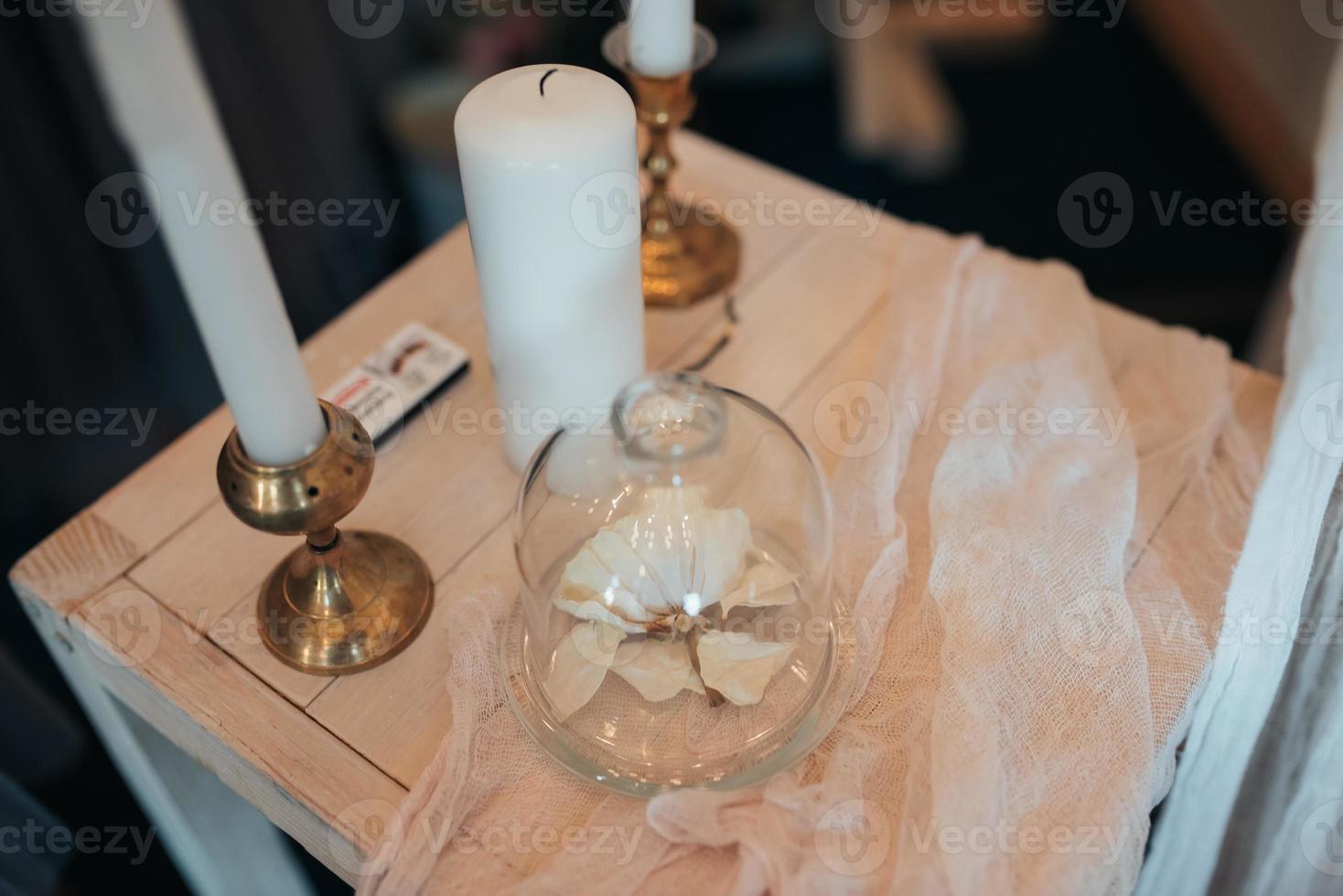 kleine bruiloftstafel in het wit met kaarsen en bloemen foto