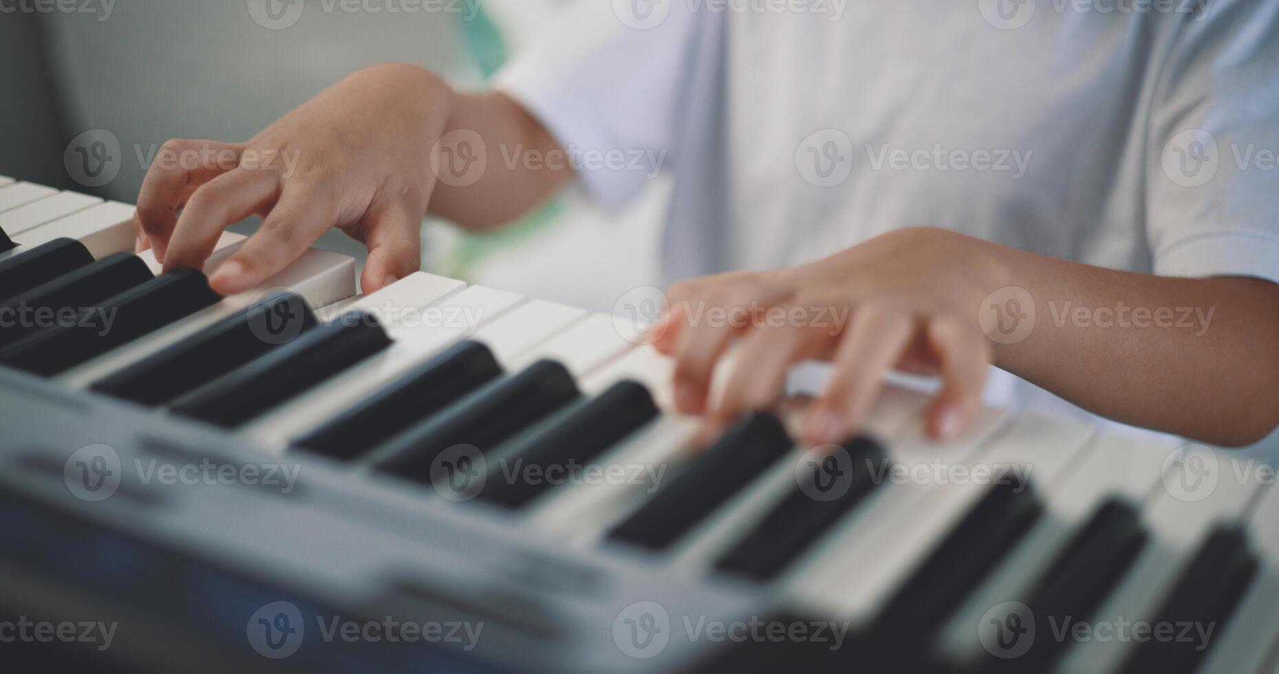 schattig jongen genieten naar aan het leren spelen piano Bij huis foto