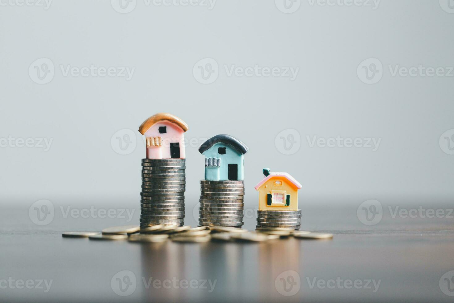 munten stack met mini huis Aan houten tafel, huis lening, opslaan geld concept, eigendom investering, huis lening, omgekeerde hypotheek, goud munten geld stack groei, besparing geld munten stack toekomst voor huis. foto