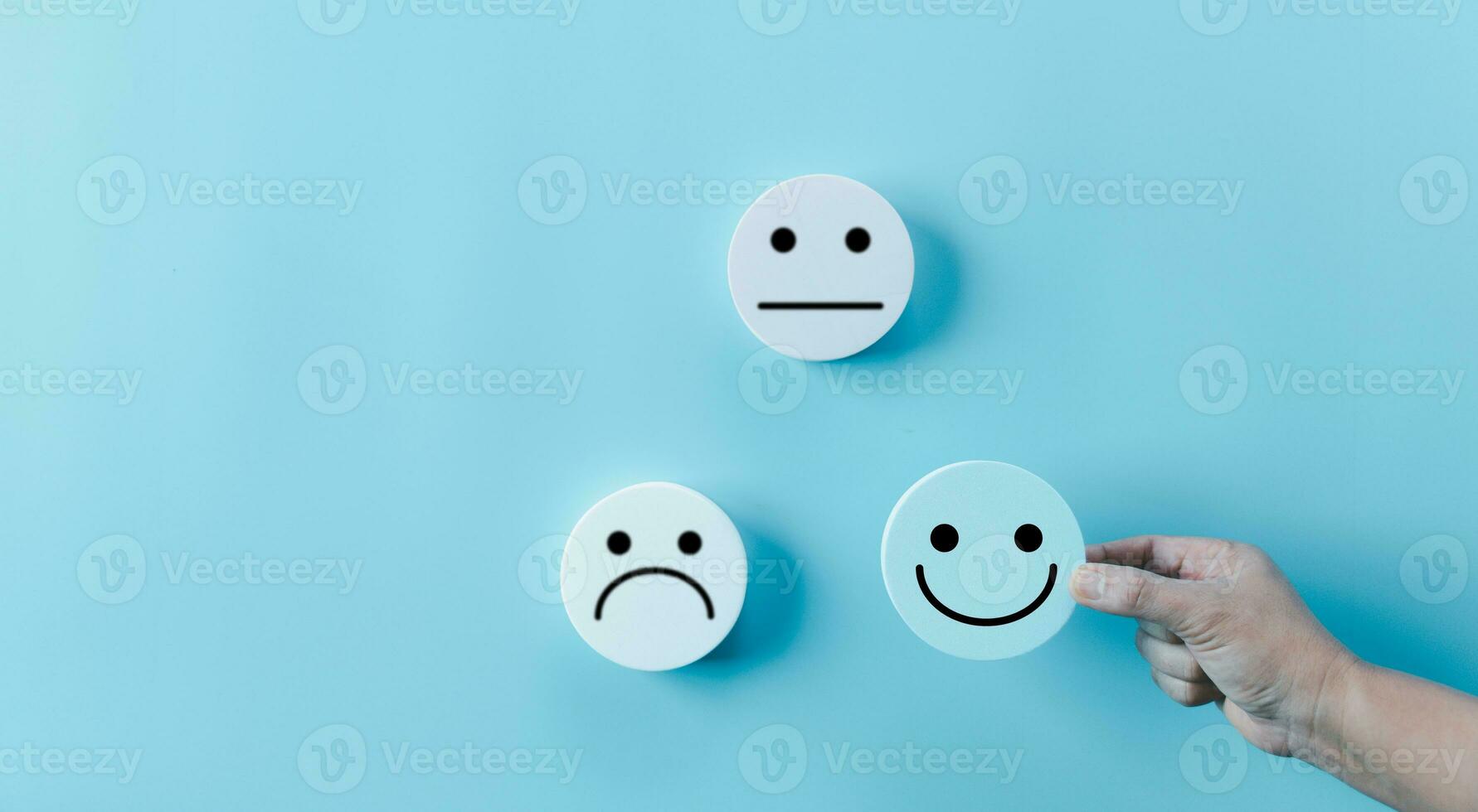 vrouw hand- Holding gelukkig gezicht glimlach gezicht icoon Aan ronde blauw voorwerp. klant ervaring en onderhoud met tevredenheid concept. positief denken, mentaal Gezondheid beoordeling, wereld mentaal Gezondheid dag. foto