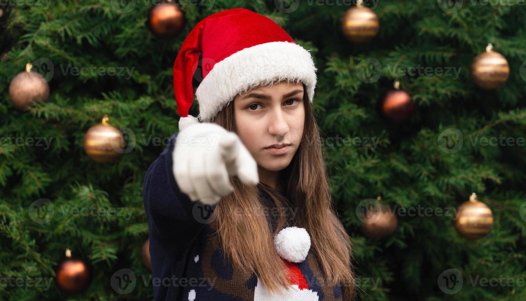 close-up portret van vrouw met een hoed van de kerstman en medische masker met emotie foto