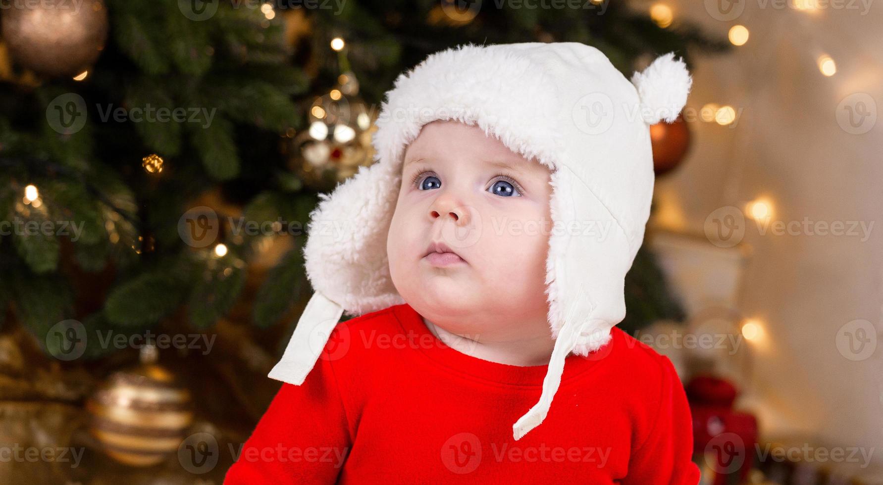 een schattig klein meisje in een rode jurk en een witte hoed drukt emoties uit foto