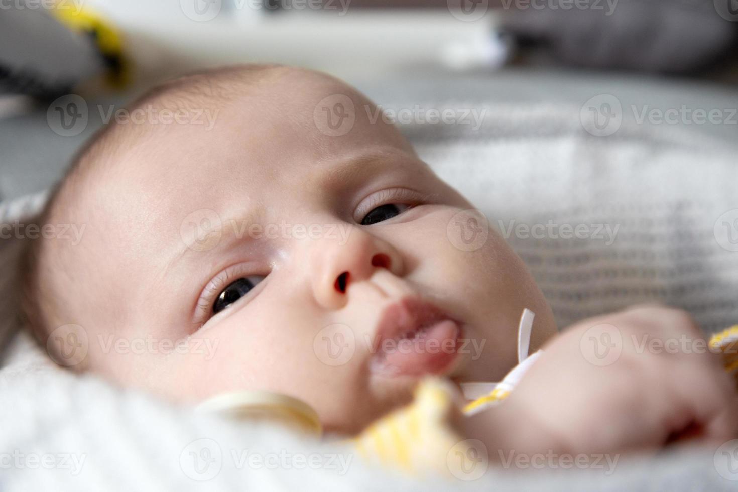 een close-upportret van een pasgeboren babymeisje dat kwijlt foto