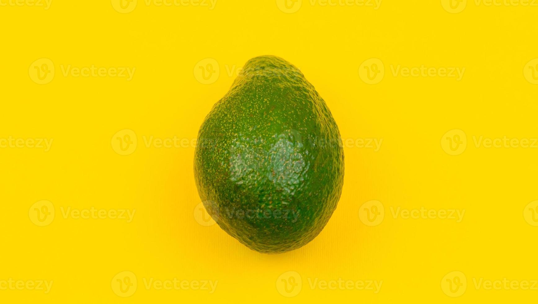 hele avocado op gele houten achtergrond foto