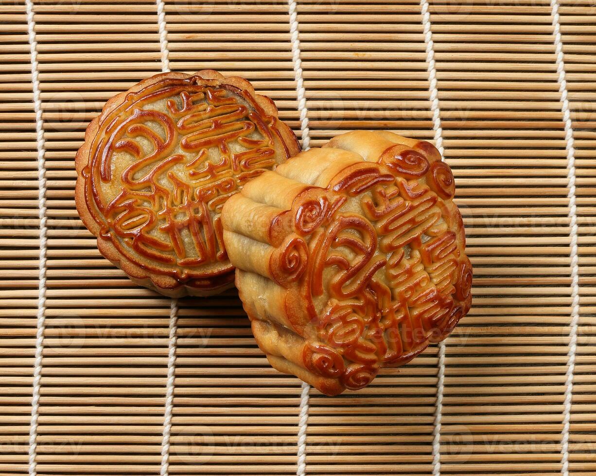 Chinese gebakken versierd mooncake midden herfst festival plein ronde maan taart vulling geschenk wens aanbieden Aan bamboe mat over- houten tafel mini kop foto