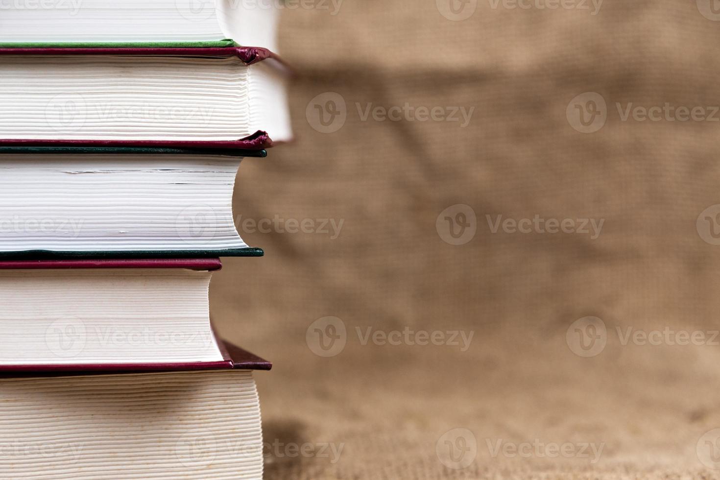 een stapel of gebonden oude boeken op een jutetextuur met plaats voor tekst foto