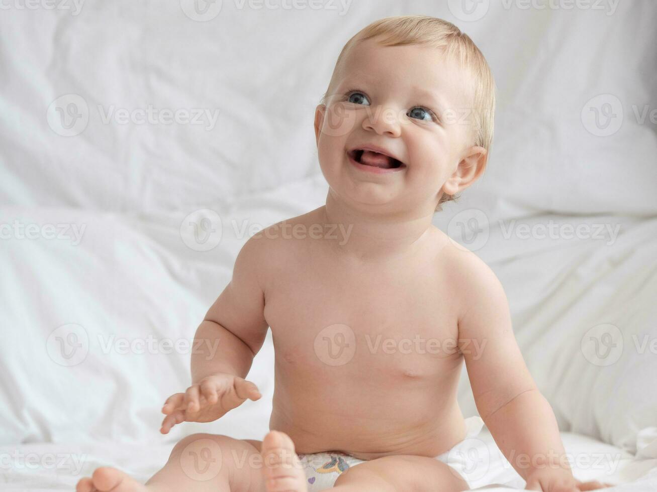 schattig baby zittend en glimlachen Aan de bed foto
