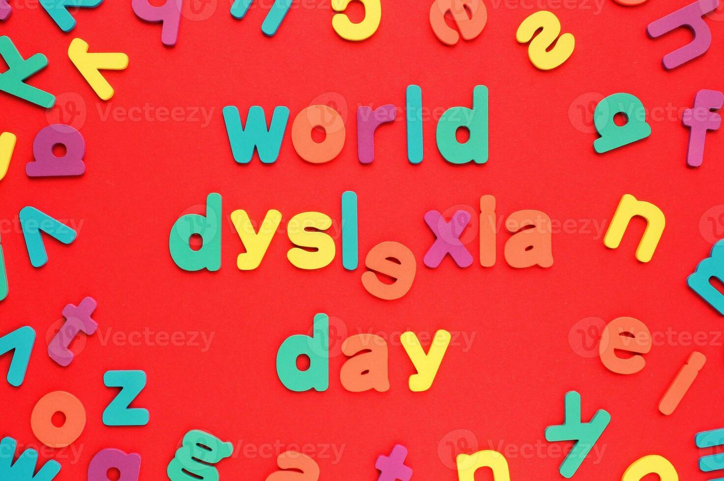 kleur alfabet brieven Aan rood achtergrond. wereld dyslexie dag concept. oplossen de leerzaam probleem van lezing. medisch en mentaal Gezondheid bewustzijn. logopedie, psychologie, aan het leren lessen foto