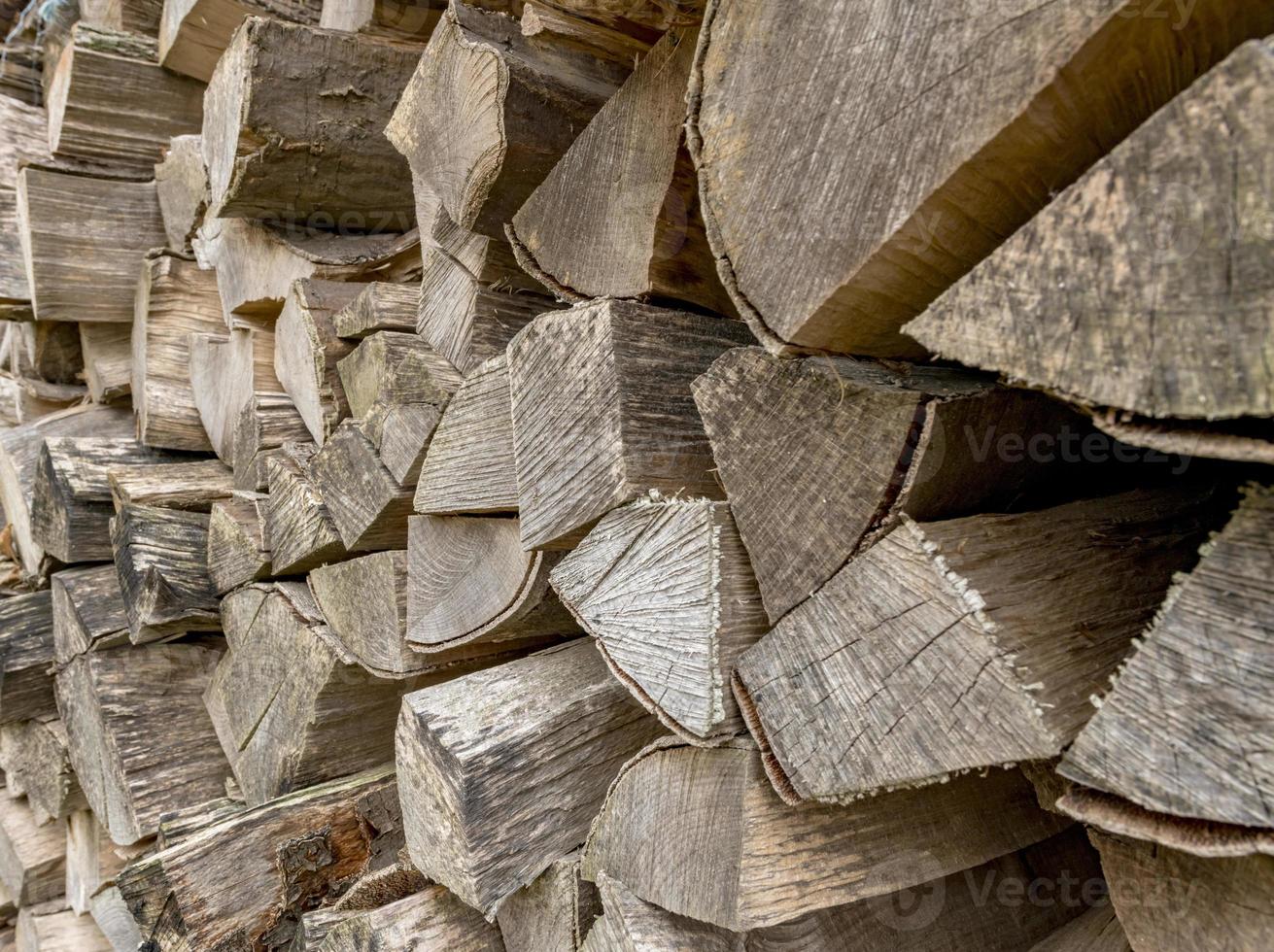 oude gespleten verweerde boomstammen gestapeld als brandhout foto