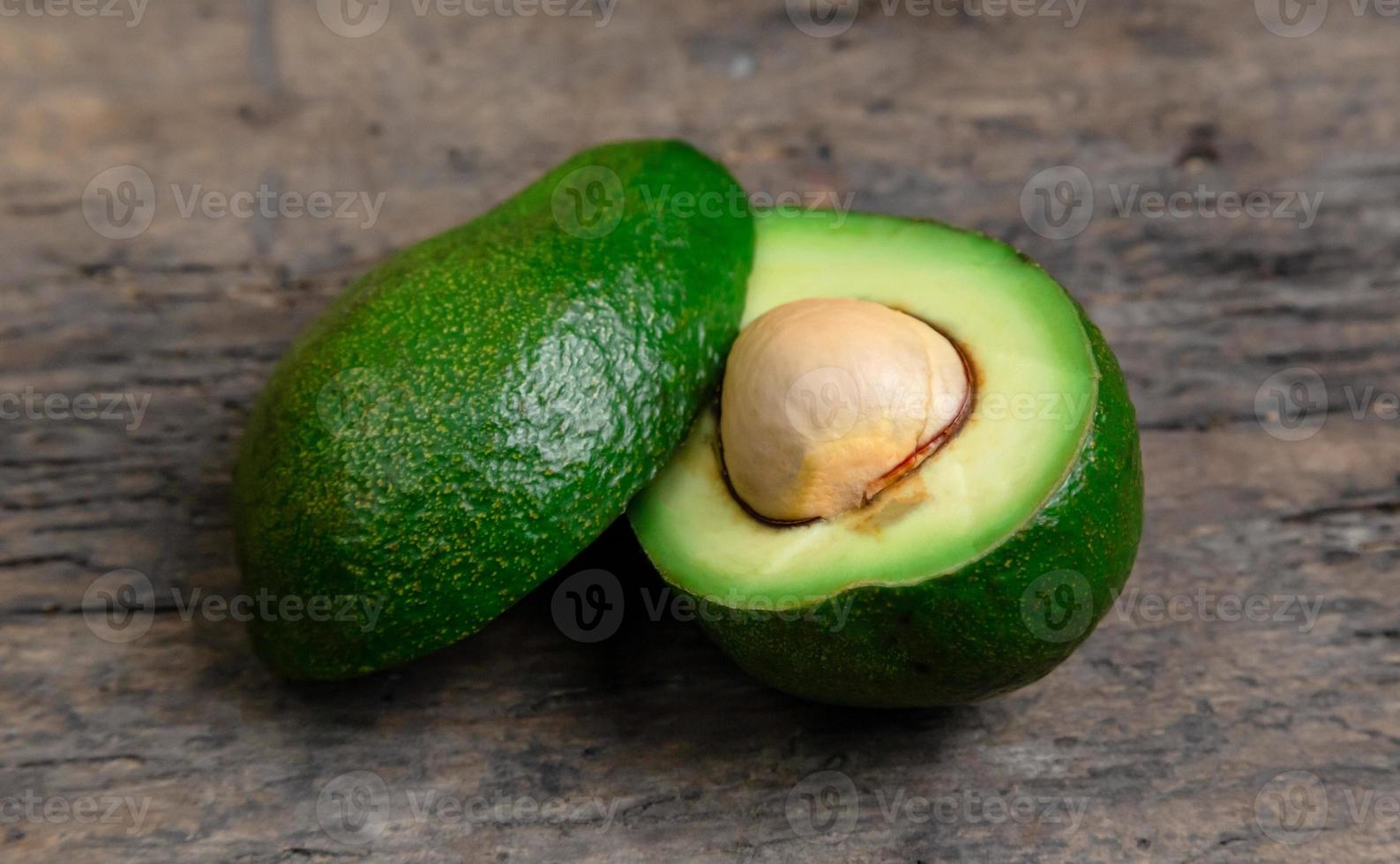 verse avocado in tweeën gesneden op een houten bord achtergrond foto