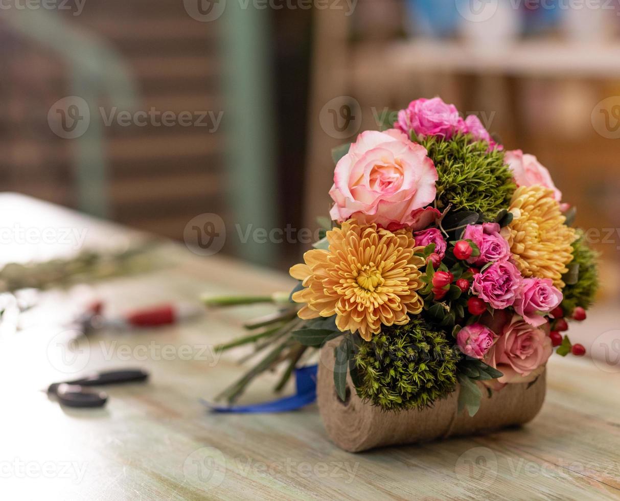 mooi bloemboeket in de tafel met apparatuur voor boeketbloemist foto