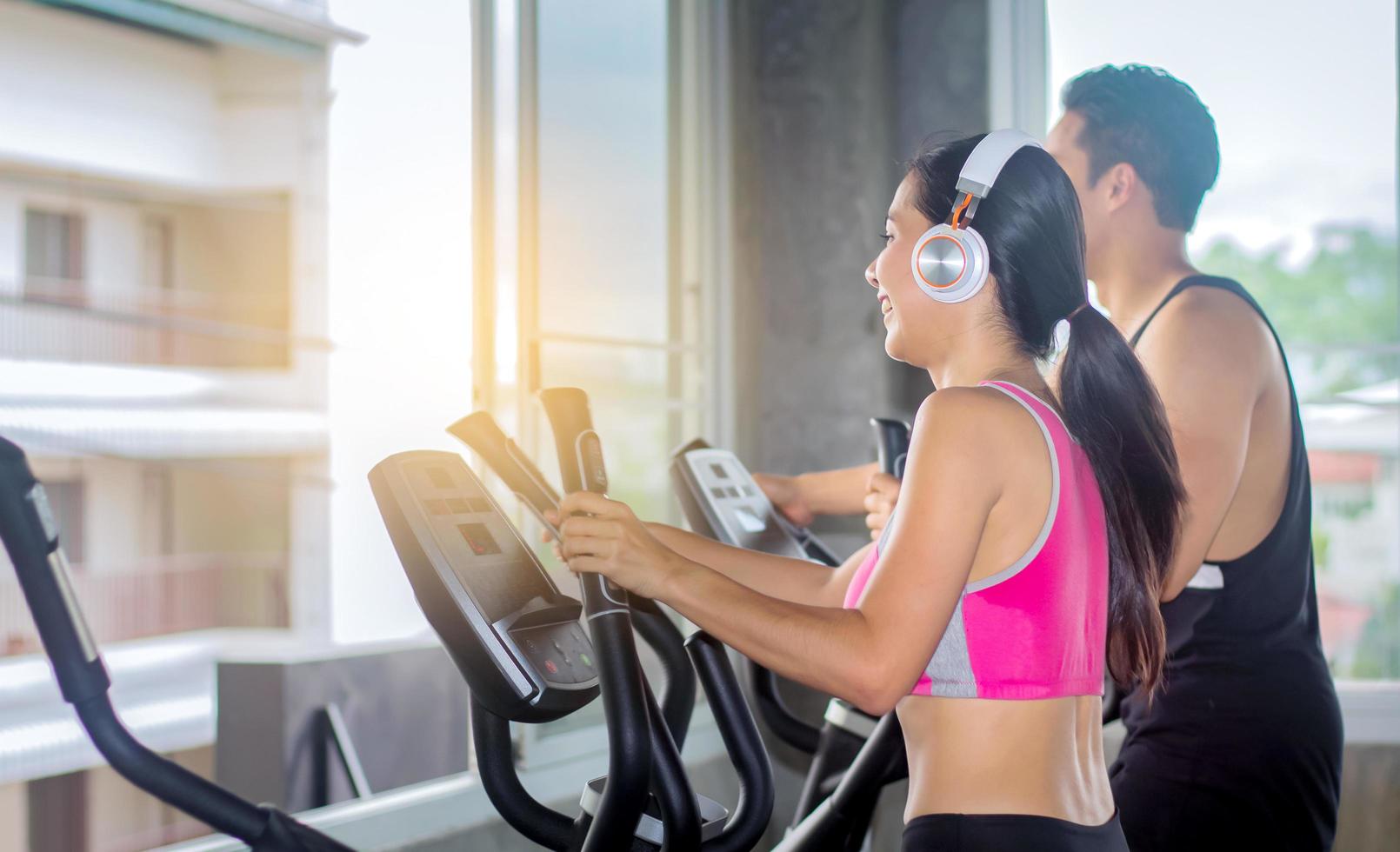 mooie Aziatische vrouw traint in een sportschool met een personal trainer foto