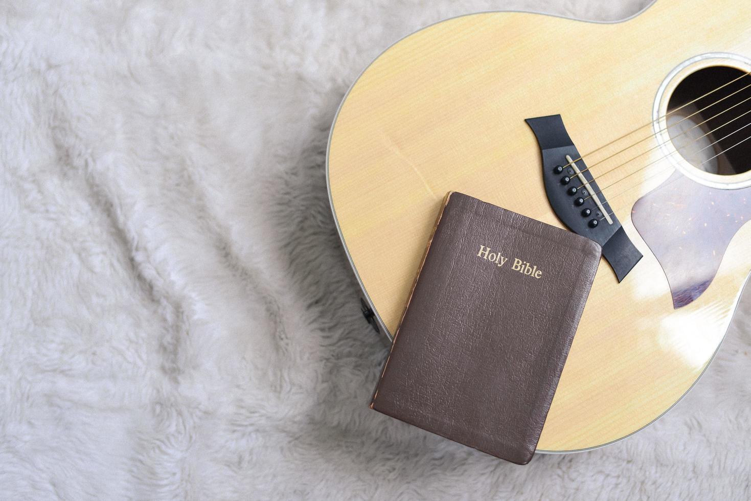 heilige bijbel op een gitaar met een harige achtergrond, christelijke eredienst foto