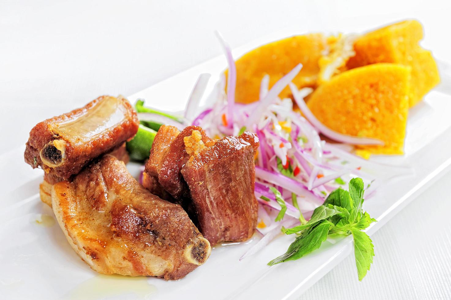 traditionele Peruaanse maaltijd genaamd chicharron de panceta de cerdo geserveerd in een restaurant foto