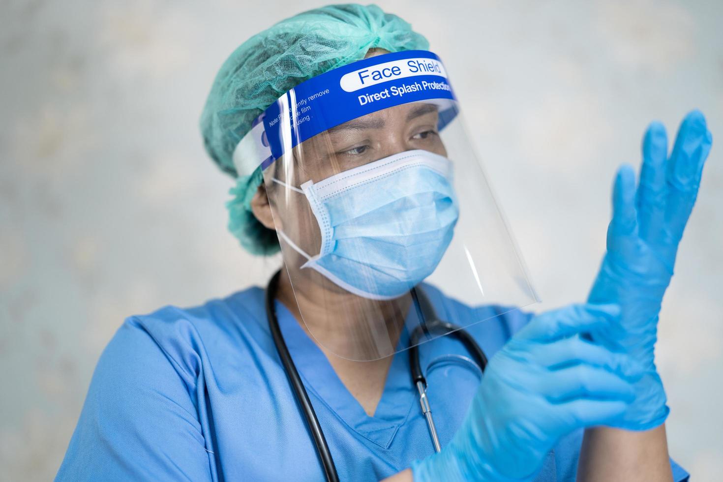 Aziatische arts draagt gezichtsscherm en pbm-pak nieuw normaal om patiënt te controleren veiligheid te beschermen infectie covid 19 coronavirus-uitbraak op quarantaine verpleegziekenhuis foto