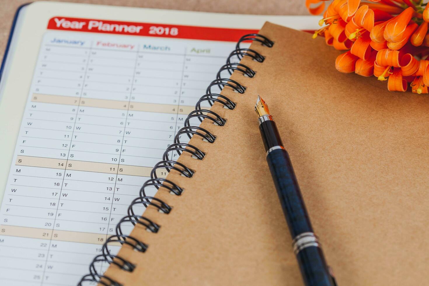 persoonlijk organisator of ontwerper met fontein pen Aan hout tafel. foto