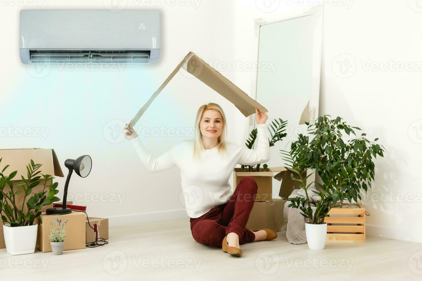 gelukkig vrouw ademen vers lucht zitten. vrouw in een nieuw appartement onder lucht conditioning foto