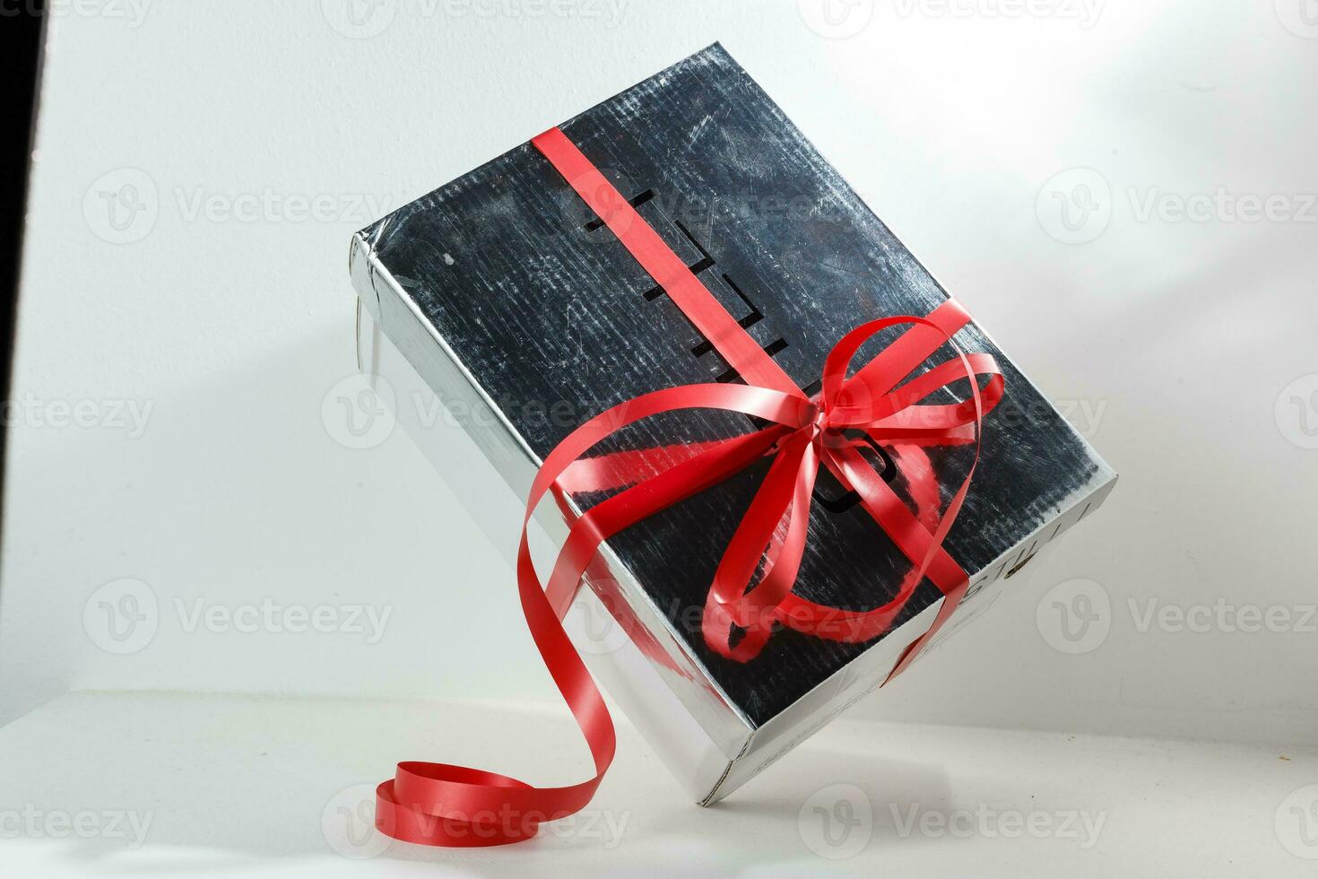 zilver geschenk doos Aan wit achtergrond. zilver geschenk doos met rood lintje. foto