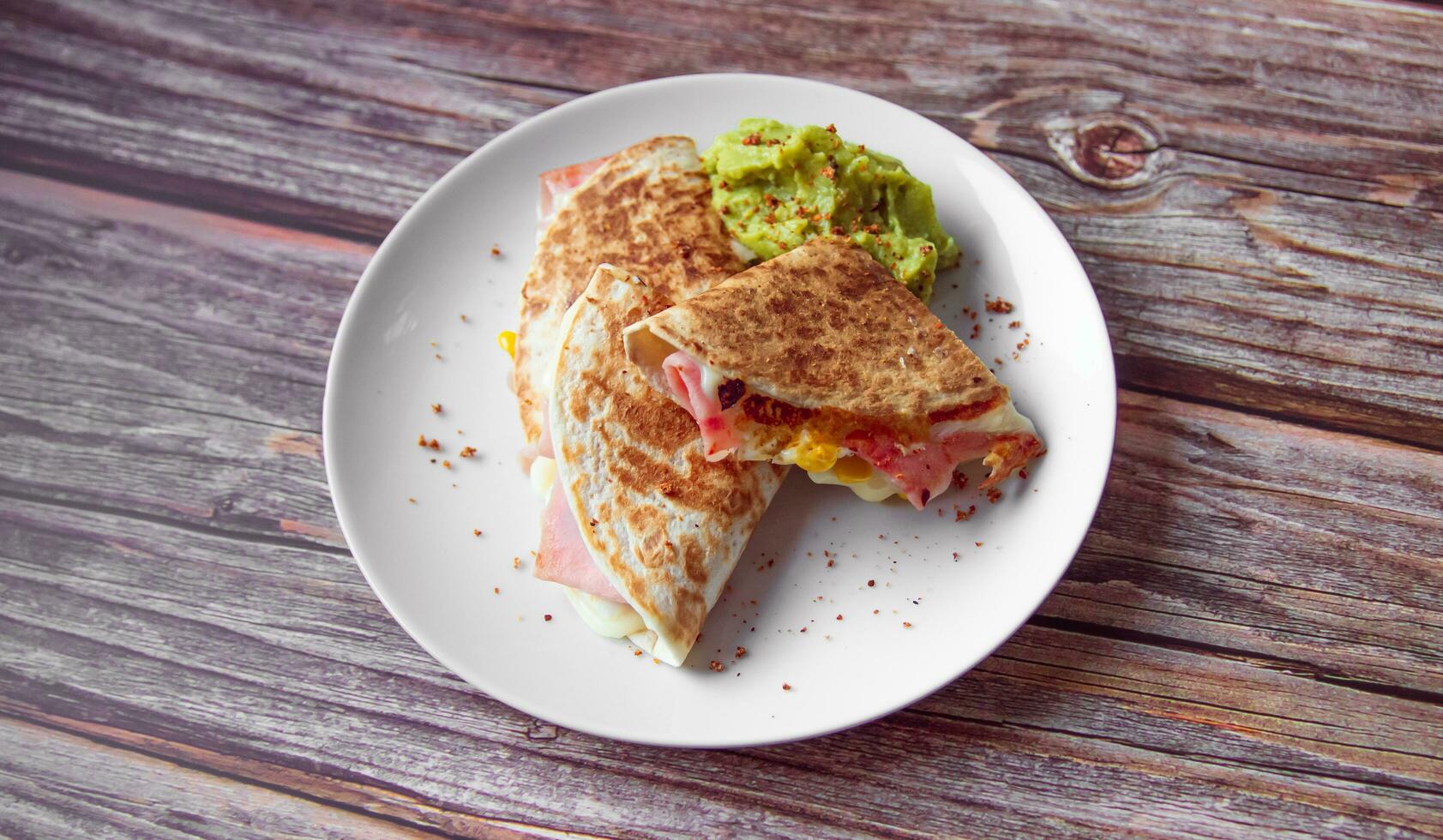 een bord van voedsel met een Quesadilla en guacamole Aan het. foto