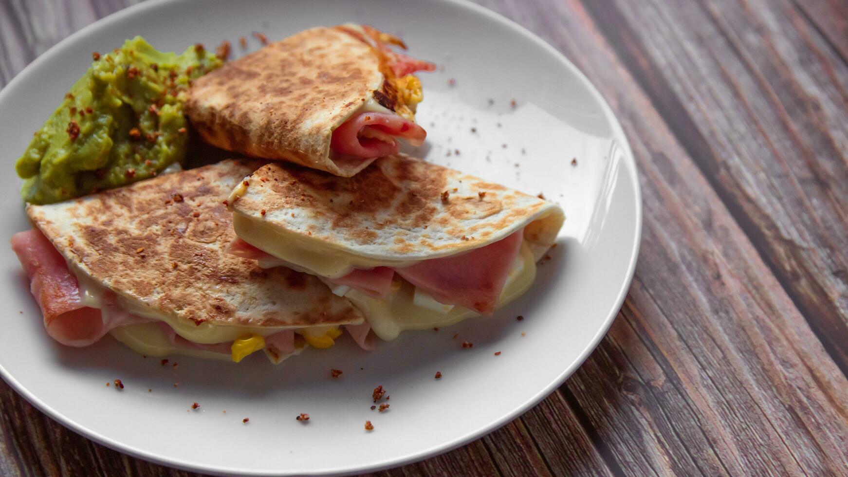 een bord van voedsel met een Quesadilla en guacamole Aan het. foto