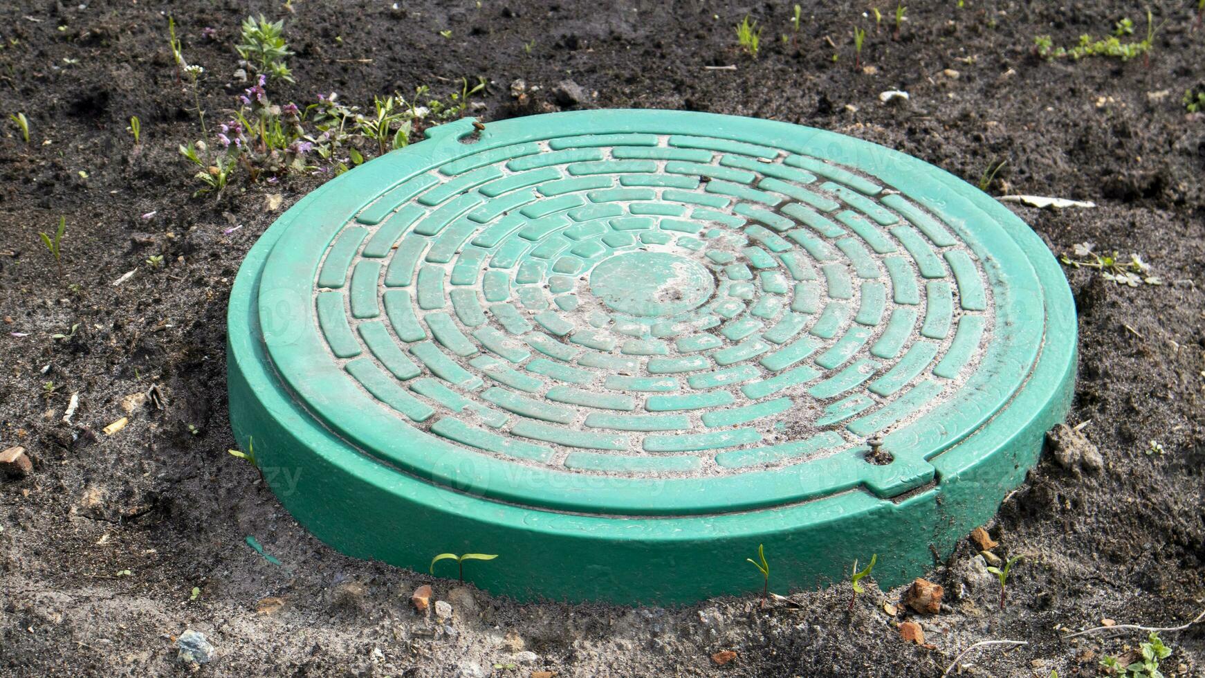 nieuw groen metaal mangat Aan de land. reparatie werk. de Gesloten zonnedak doet niet houding een Gevaar naar voetgangers en voertuigen. ondergronds pijpleiding reparatie. foto