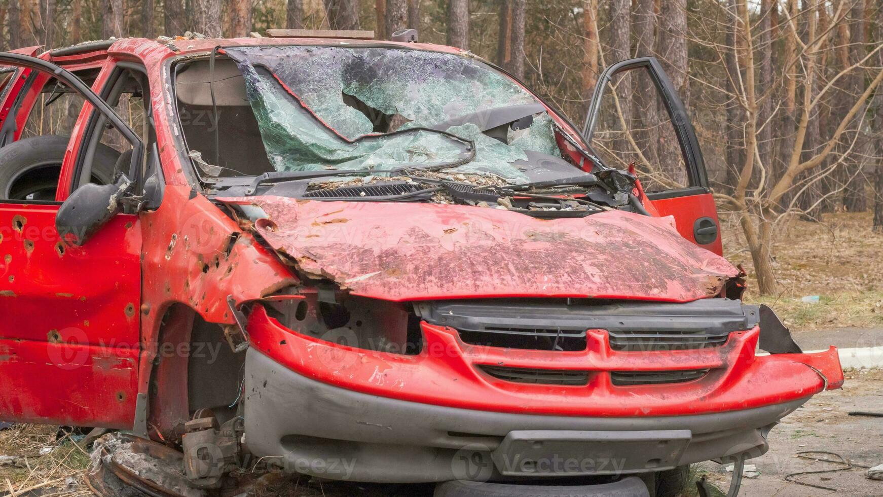 roestig en gebroken rood verlaten auto Aan de stad straat. verlaten oud auto ongeluk buitenshuis. oud verlaten roestig auto zonder wielen Aan de kant van de weg. foto