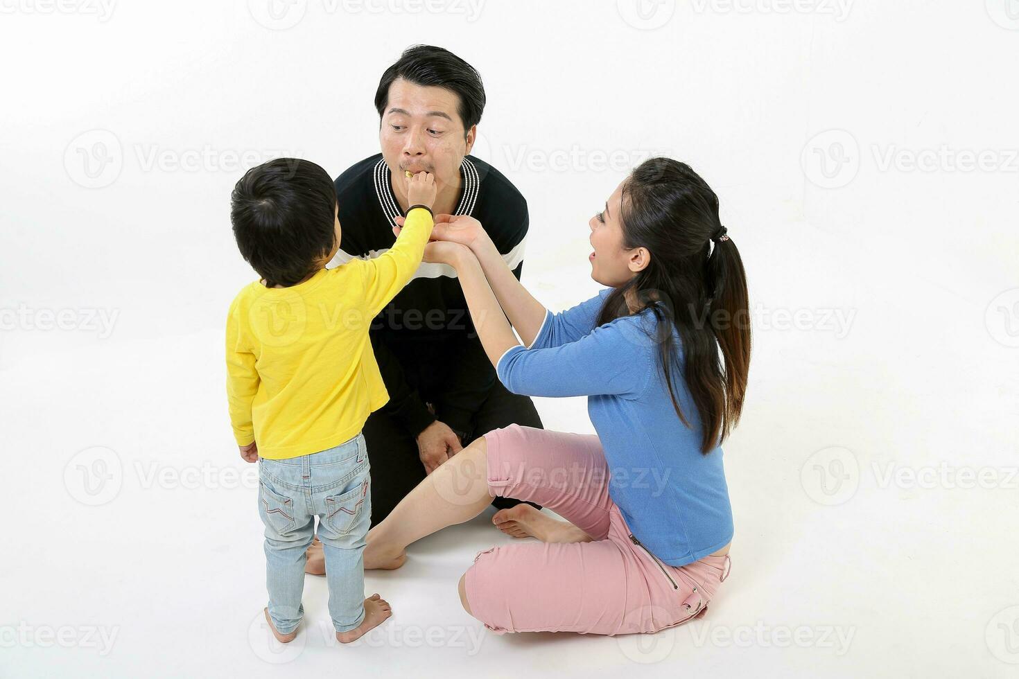 zuiden oosten- Aziatisch Chinese paar man vrouw zoon kind Speel zitten Aan verdieping eten traktatie wit achtergrond liefde foto