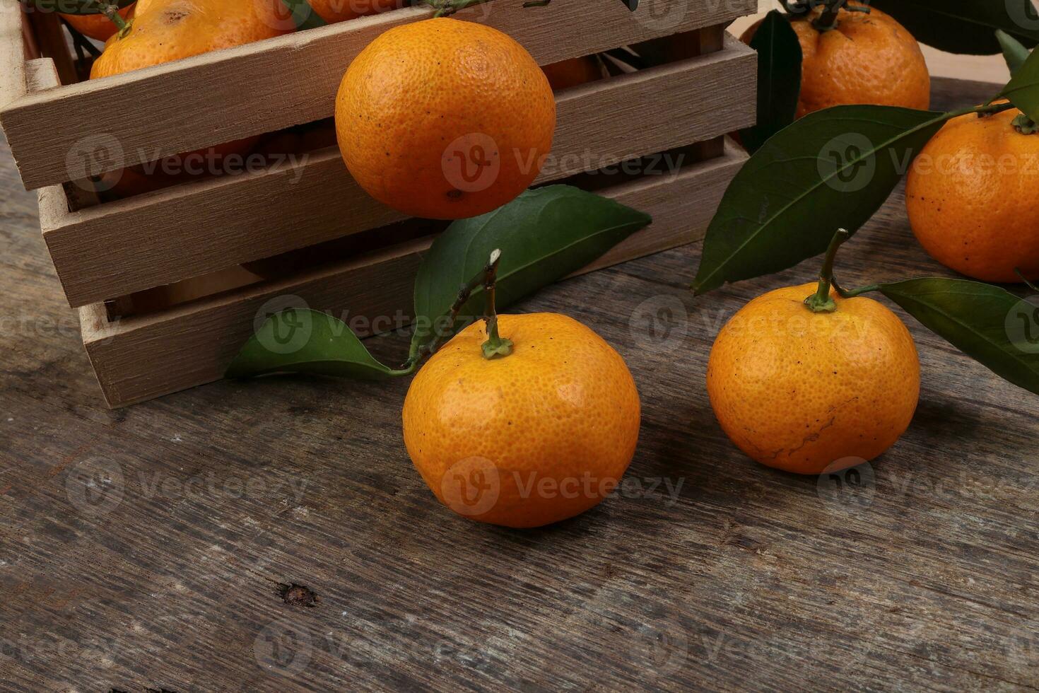 mandarijn- oranje groen blad hout krat doos Aan rustiek houten achtergrond foto