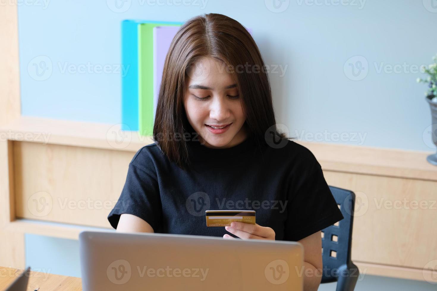 jonge vrouw met creditcard en met behulp van computer voor online winkelen foto