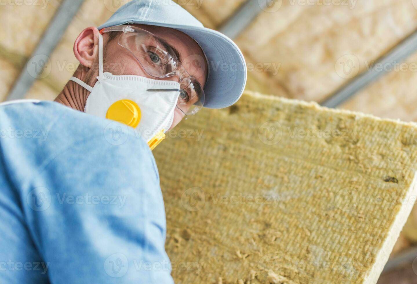 aannemer arbeider met stuk van mineraal wol huis isolatie materiaal foto