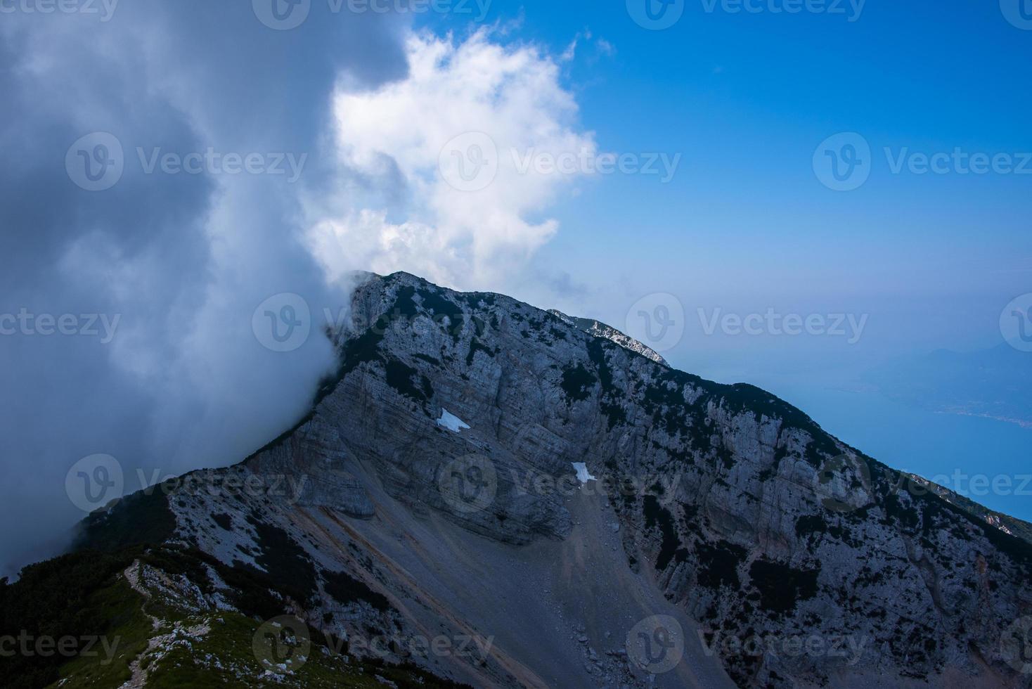 wolken boven de toppen van de alpen aan het gardameer foto