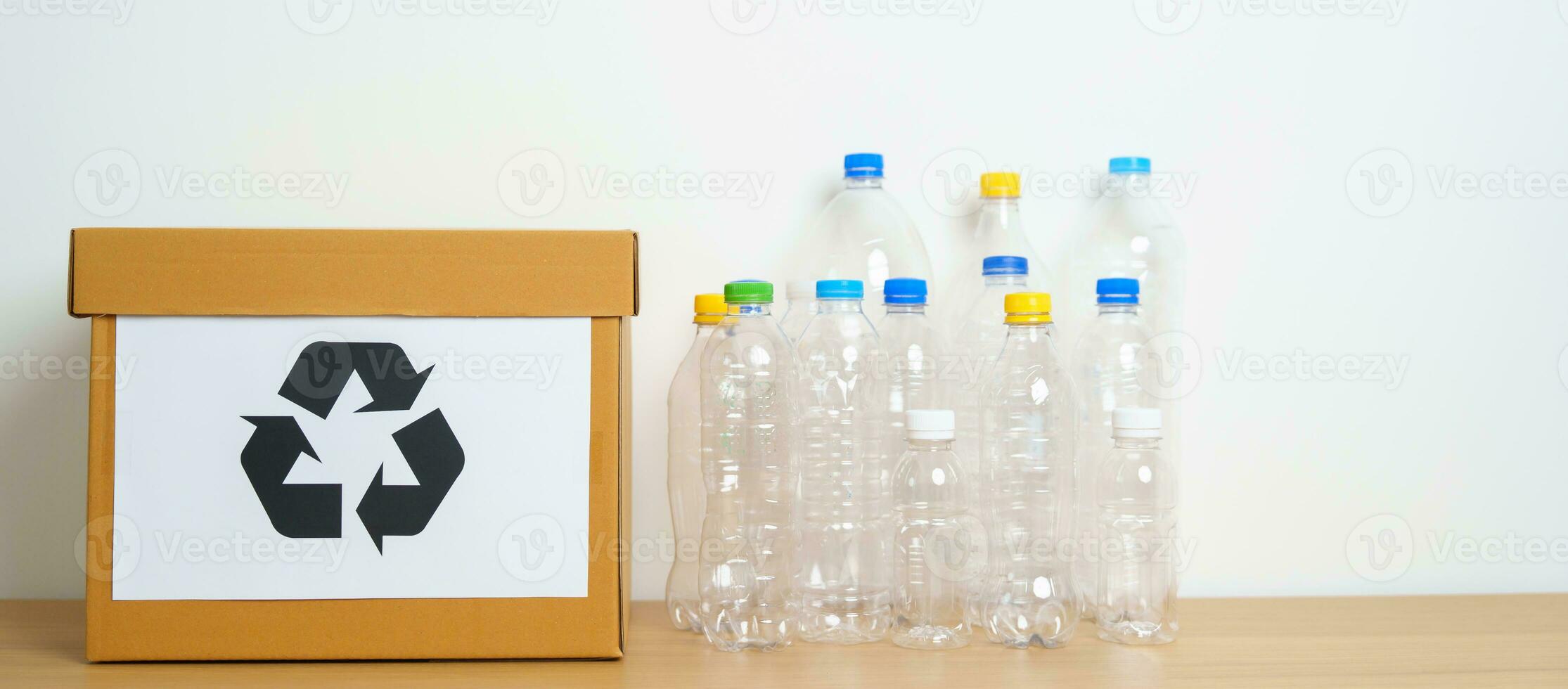 plastic fles in papier doos Bij huis of kantoor. recycle vuilnis sorteren. plastic vrij, ecologie, milieu, vervuiling, weggooien recyclen, verspilling beheer en uitschot scheiding concept foto