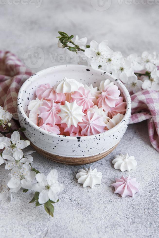 kleine witte en roze schuimgebakjes in de keramische kom foto