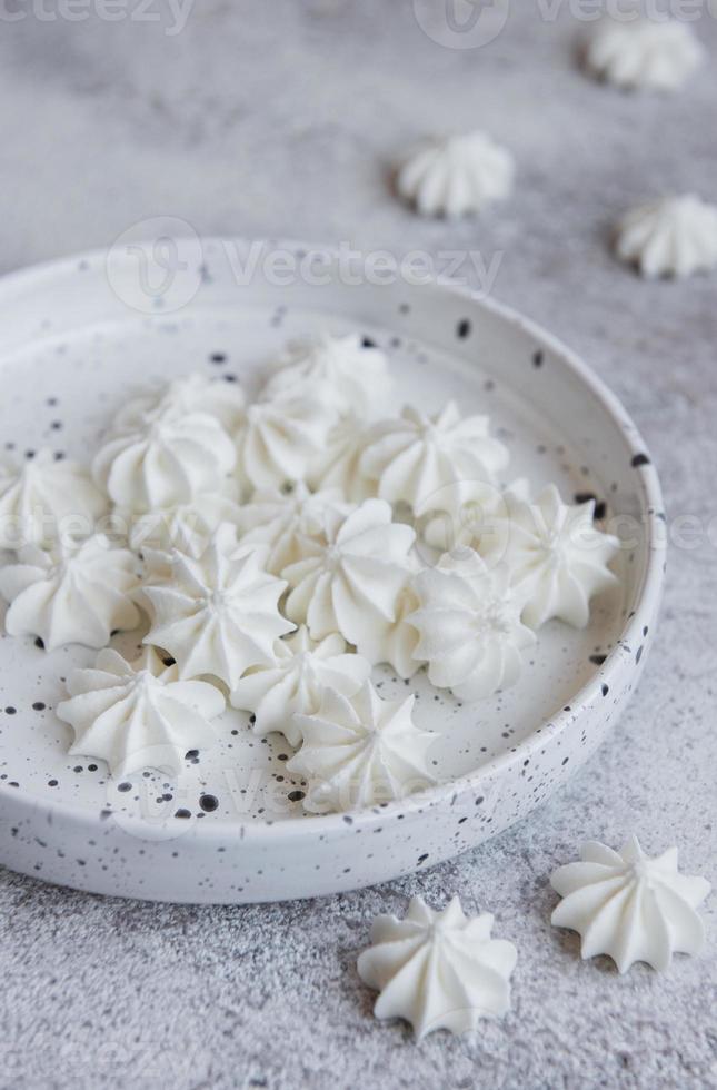 kleine witte schuimgebakjes in de keramische kom foto