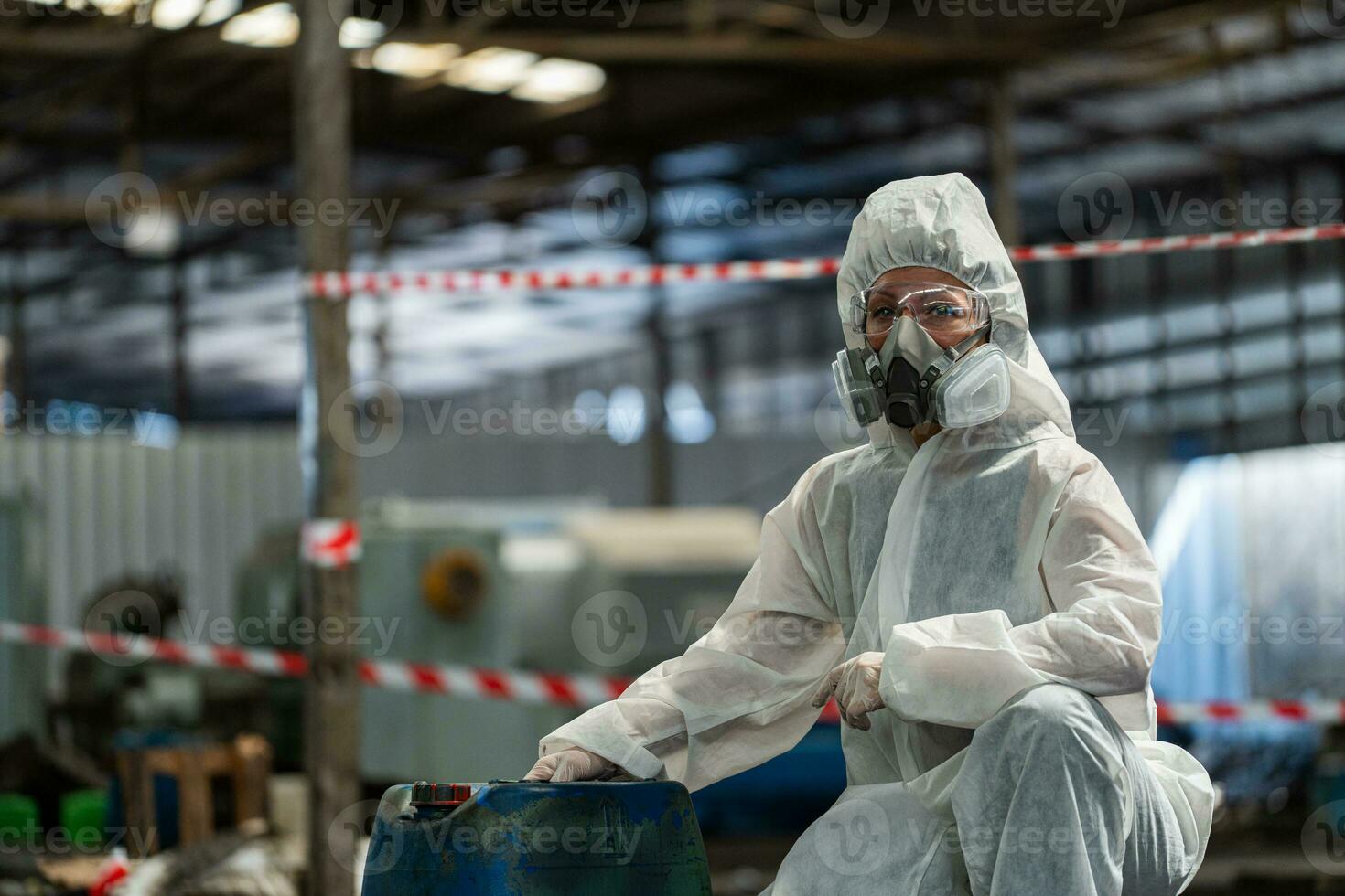 Kaukasisch vrouw arbeiders vervelend ppe beschermend kleding en gas- maskers, stofbril, Holding oud benzine tanks. foto