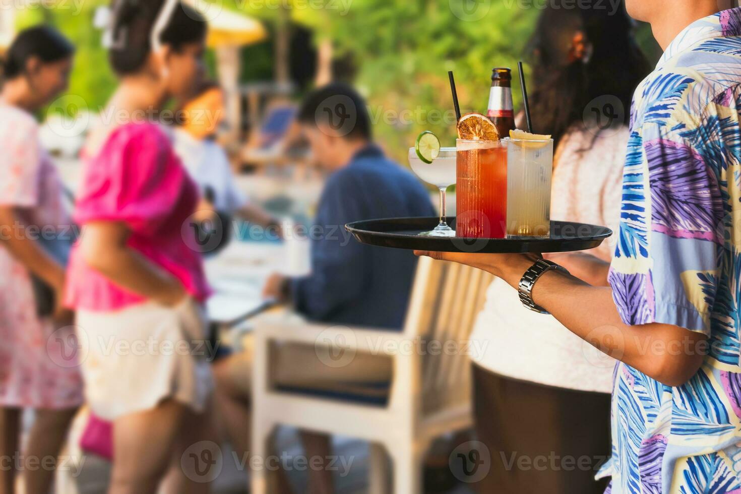 ober portie cocktail voor groep van mensen vieren. foto