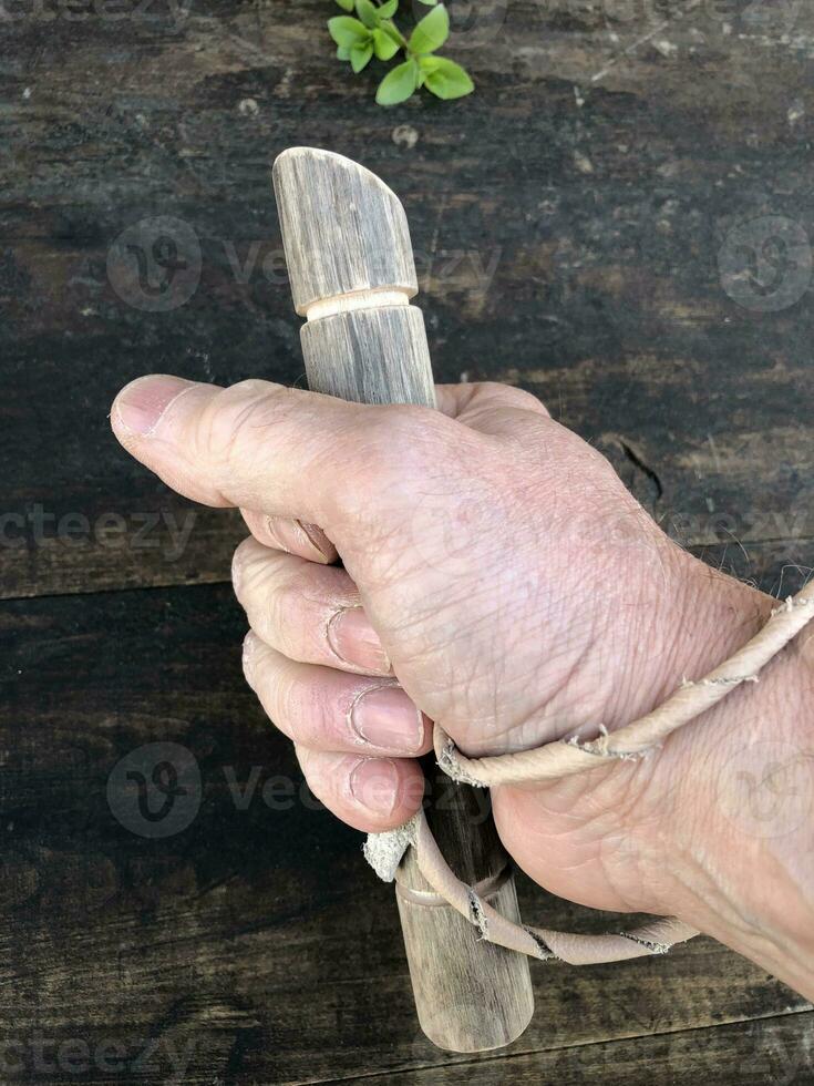 houten stok in een man's vuist, een gemakkelijk zelfverdediging wapen zwart achtergrond foto