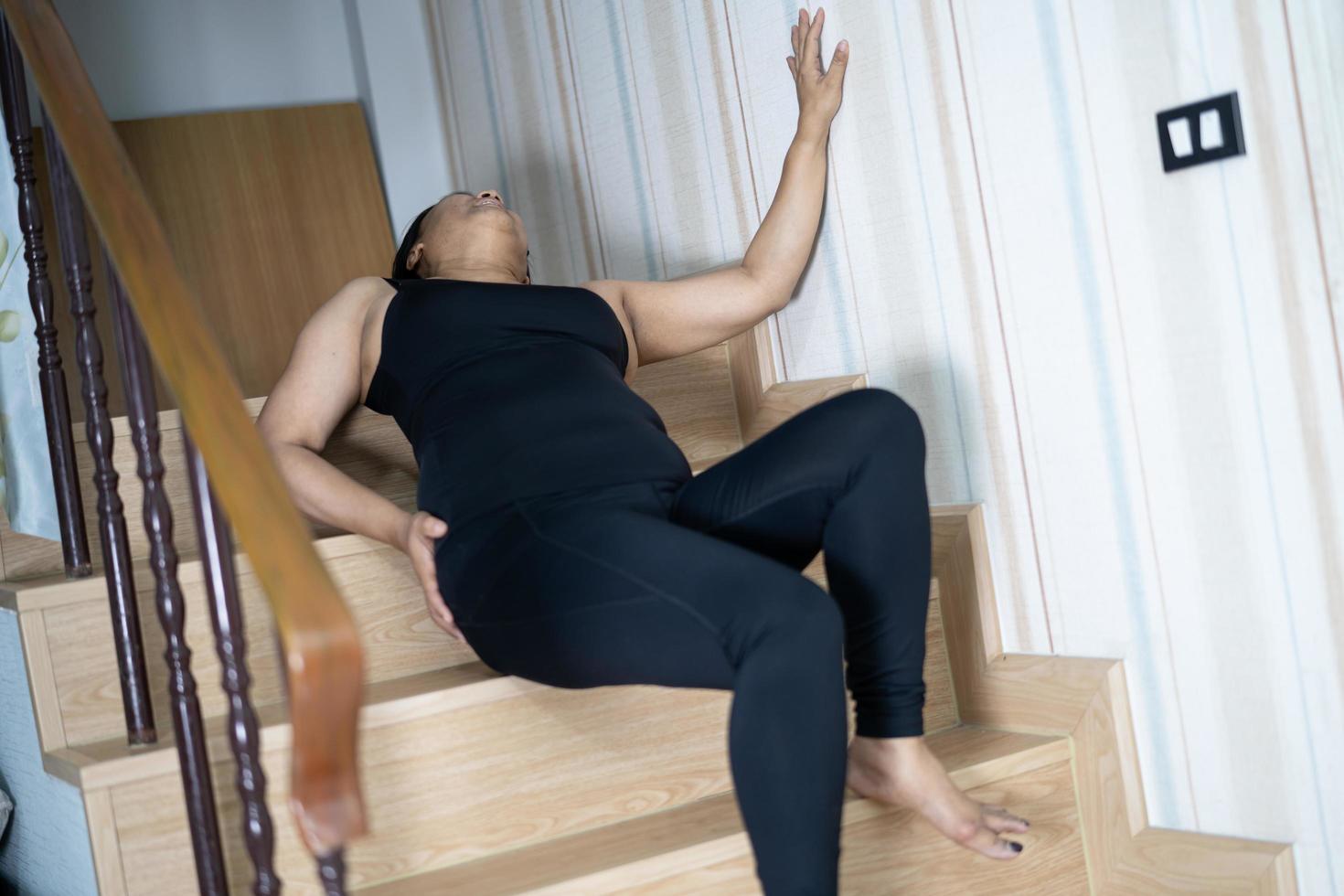 Aziatische vrouw van middelbare leeftijd vrouw patiënt van de trap vallen omdat gladde oppervlakken foto