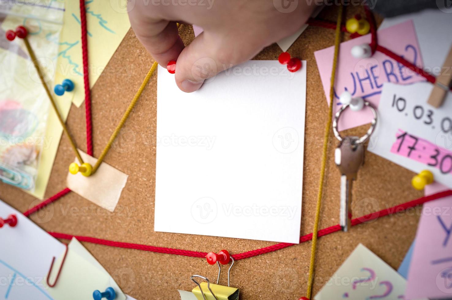 detectivebord met bewijsmateriaal met een leeg mockup wit vel foto