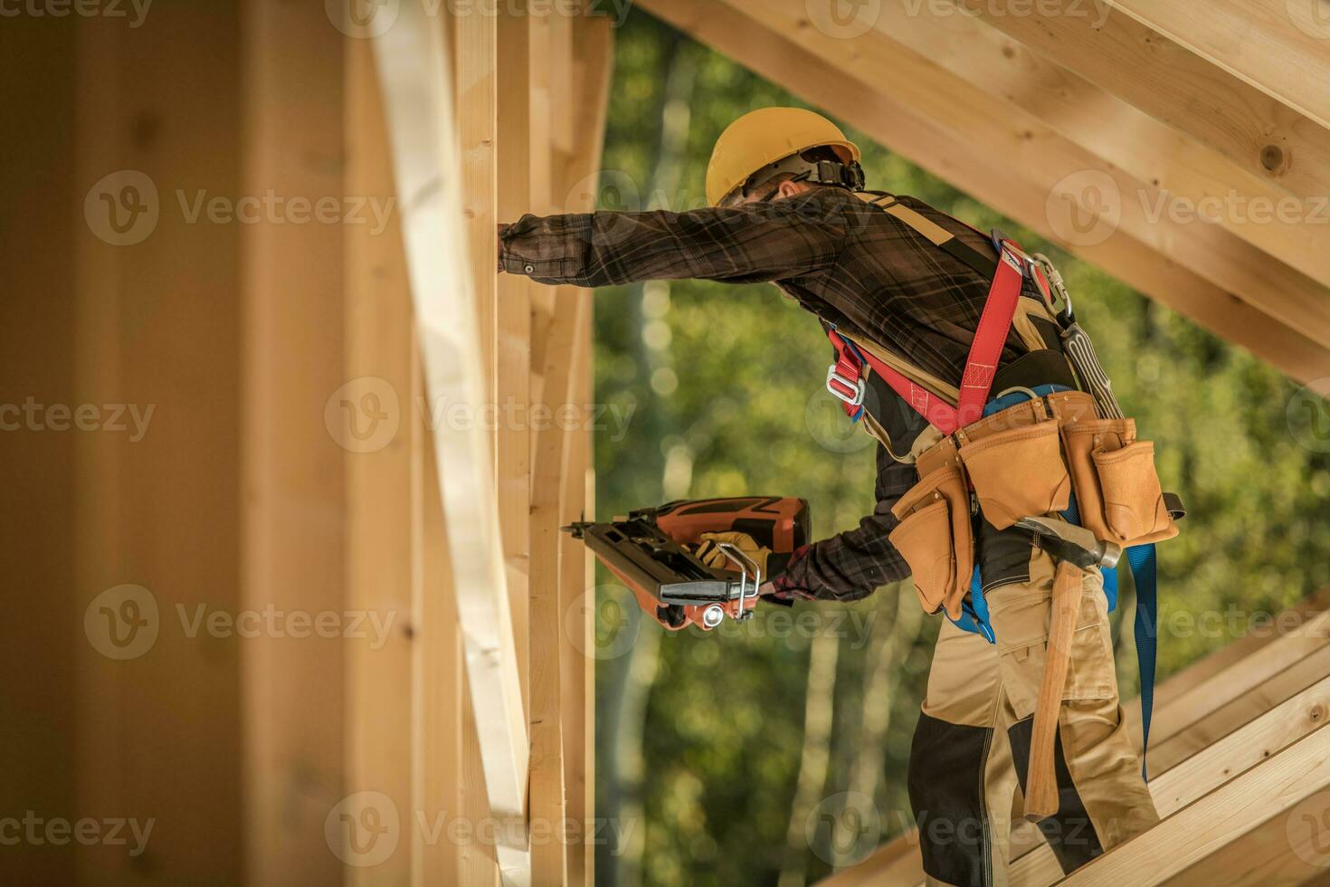 aannemer werken Aan houten skelet van de huis met nagel geweer foto