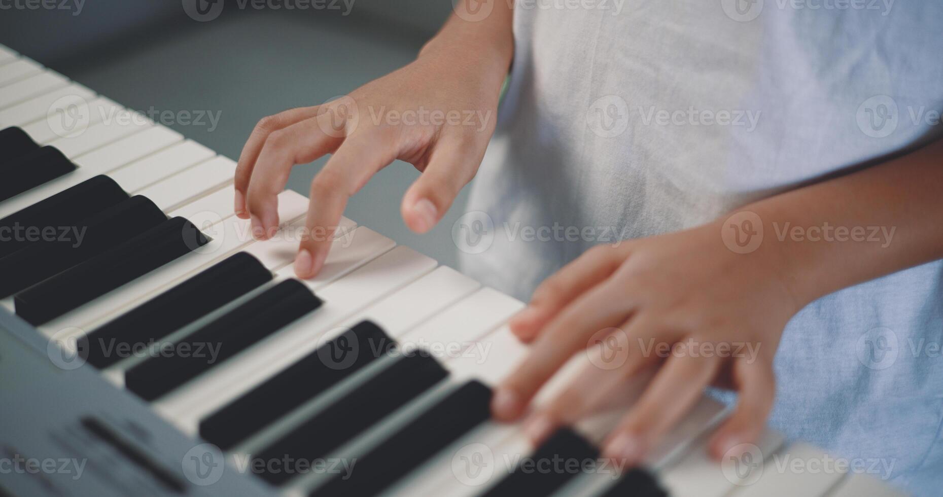 schattig jongen genieten naar aan het leren spelen piano Bij huis foto